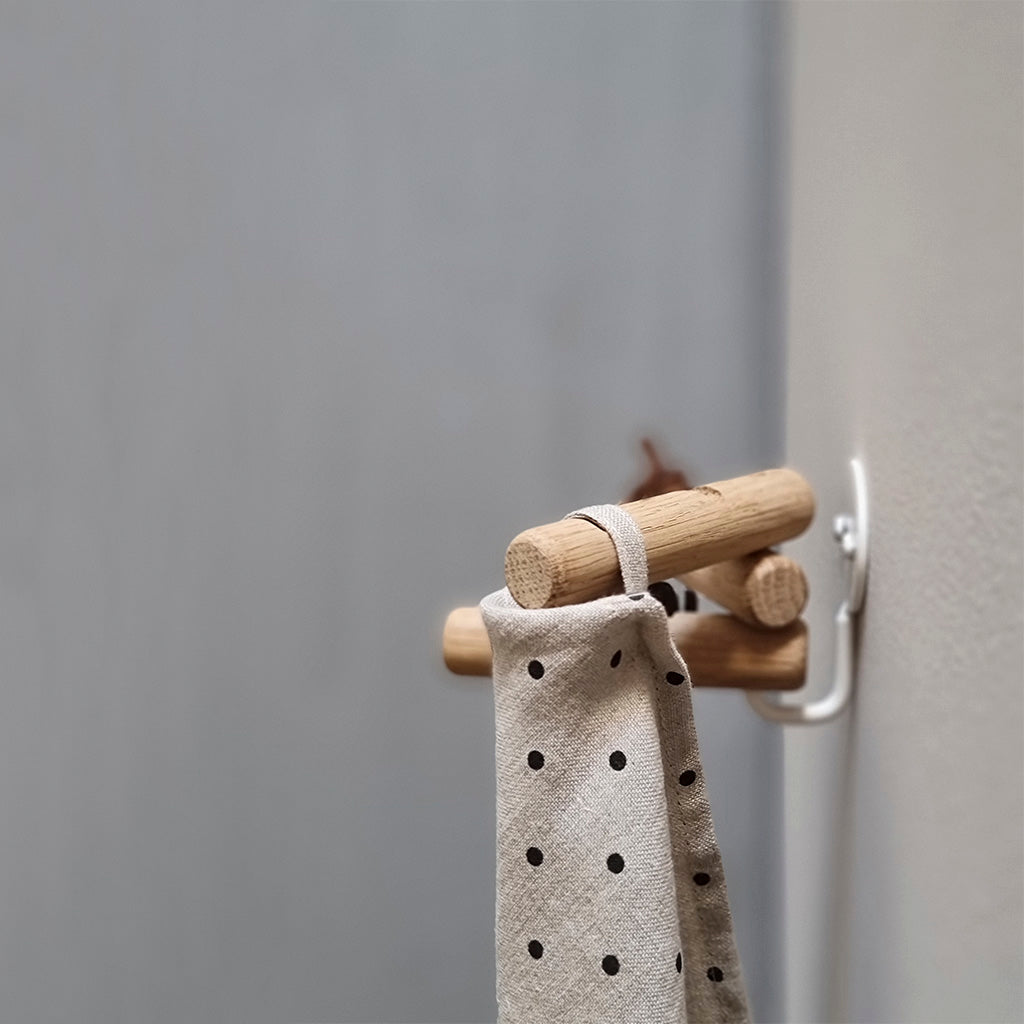 Knage i eg og hvidt stål. De tre ege kroge kan drejes efter ønske. Krogene har tre fræsninger til ophæng af viskestykker, klude mm. Monteret i væg.