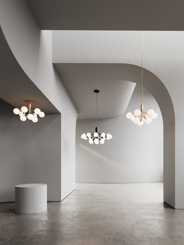 Lysekrone bestående af runde skærme i opalglas samt messingfarvet krone