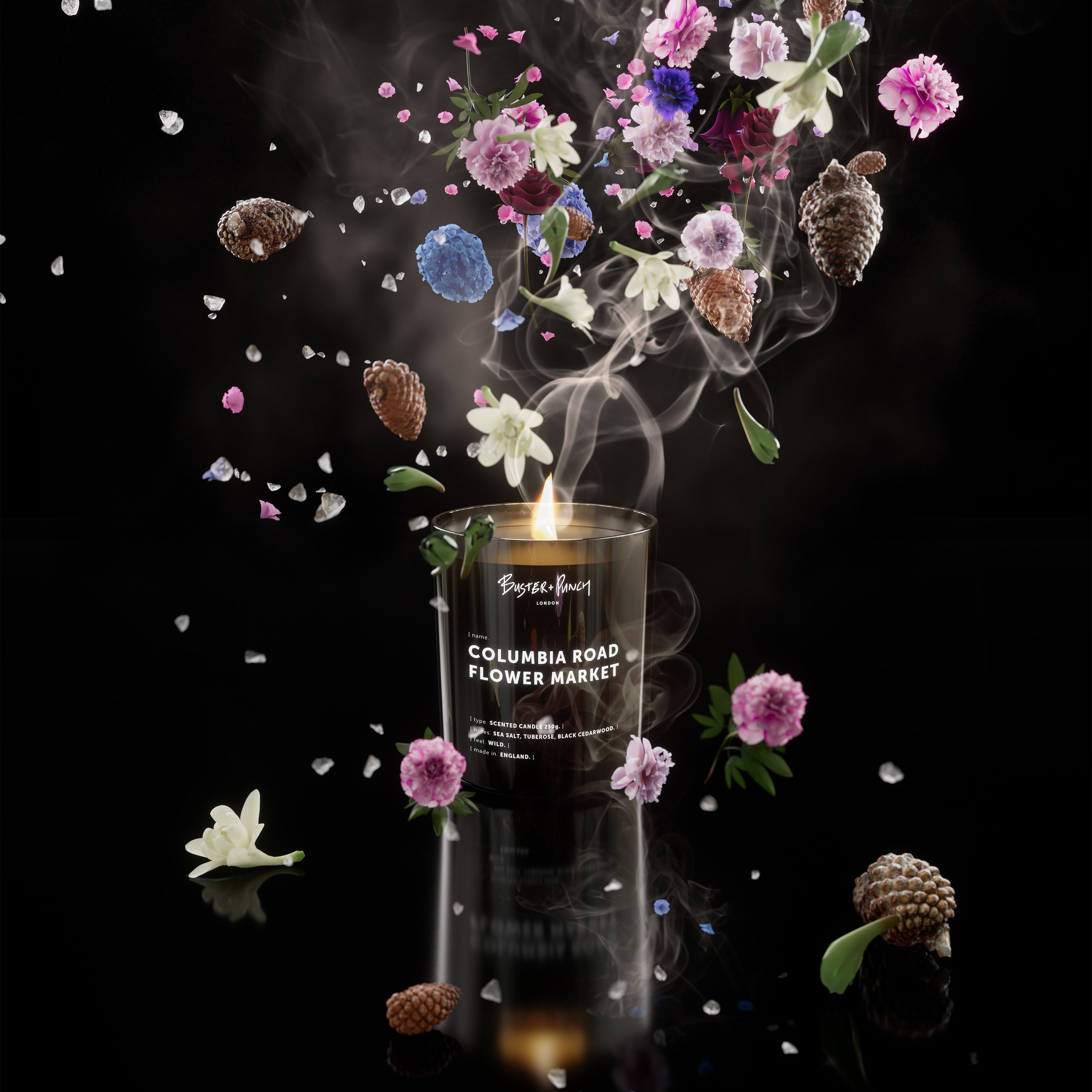 Duftlys af sort voks i røgfarvet glas, på sort baggrund.