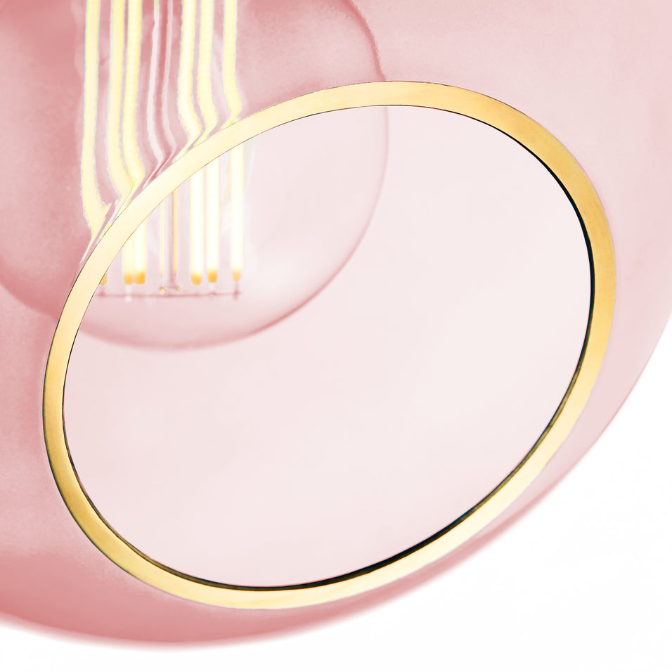 Rund lampe i rosafarvet glas og med et afskåret stykke med guldkant og kig til pæren. Fatning og rosetten er guldfarvet og ledningen er af sort stof.