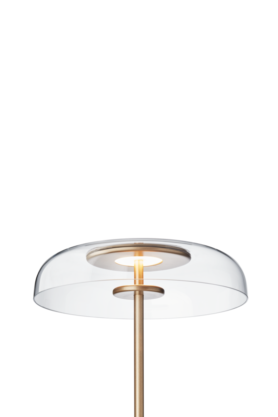 Gulvlampe med gyldent stel og fatning samt klar glasskærm, på hvid baggrund