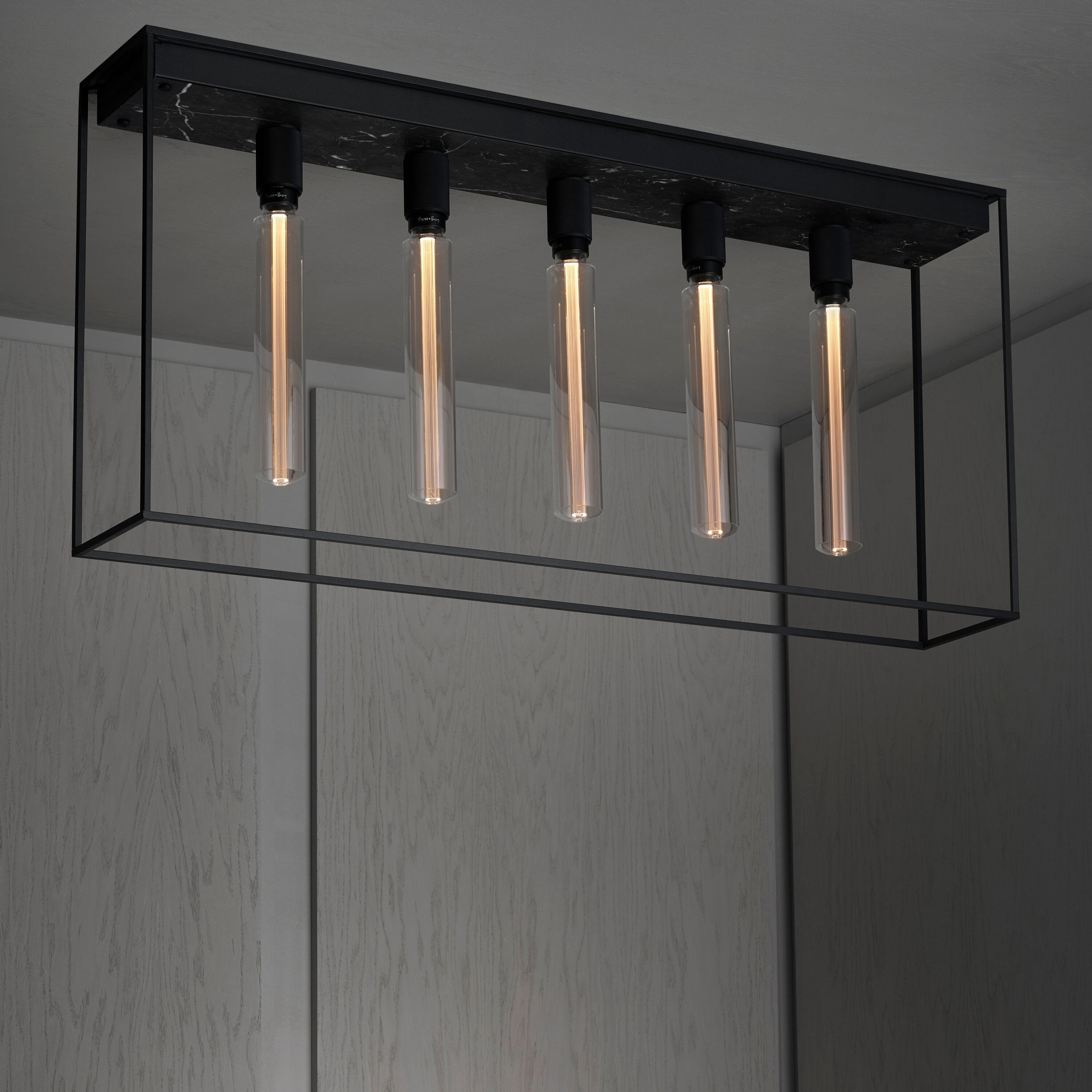 Caged loftlampe med fem pære fra Buster and Punch i sort med bagpanel i sort marmor.