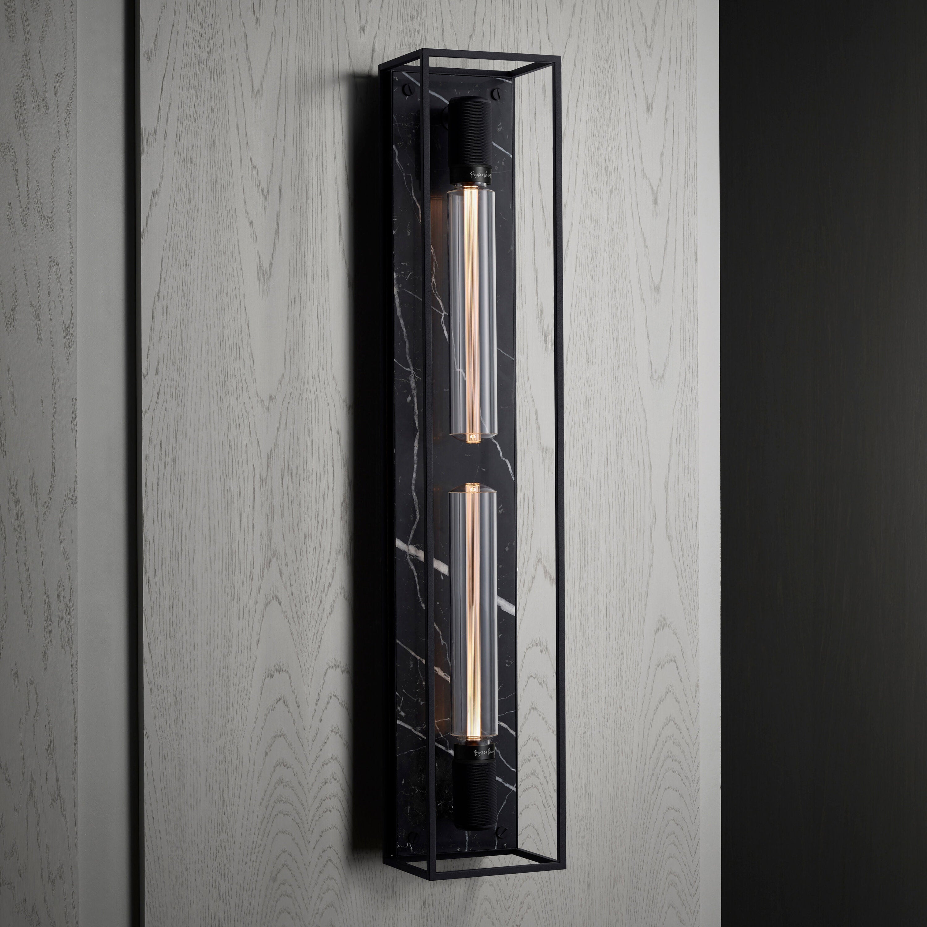 Buster and Punch caged wall lamp X-large i sort metal med bagpanel i sort marmor.