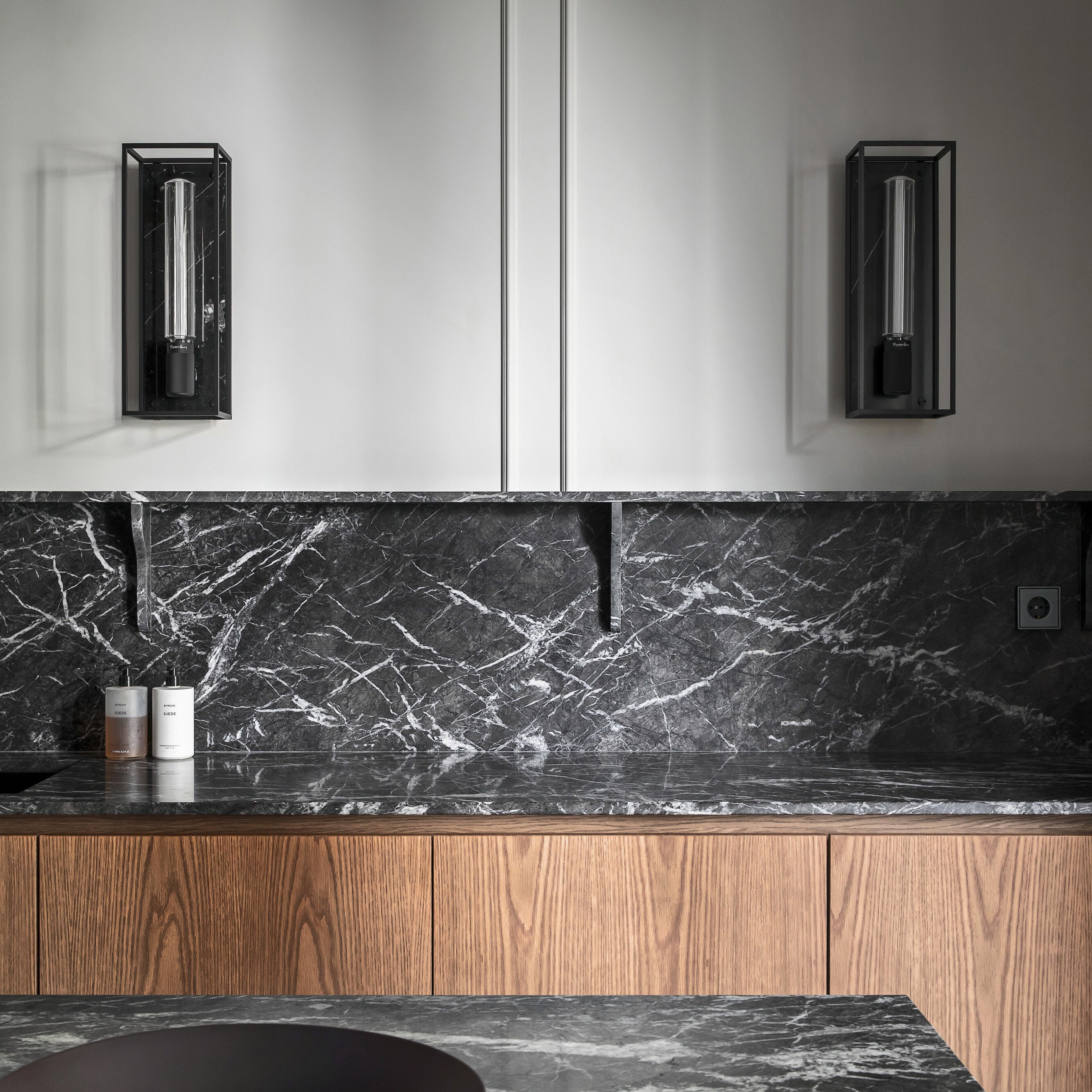 Buster and Punch caged wall lamp large i sort metal med bagplade i sort marmor.