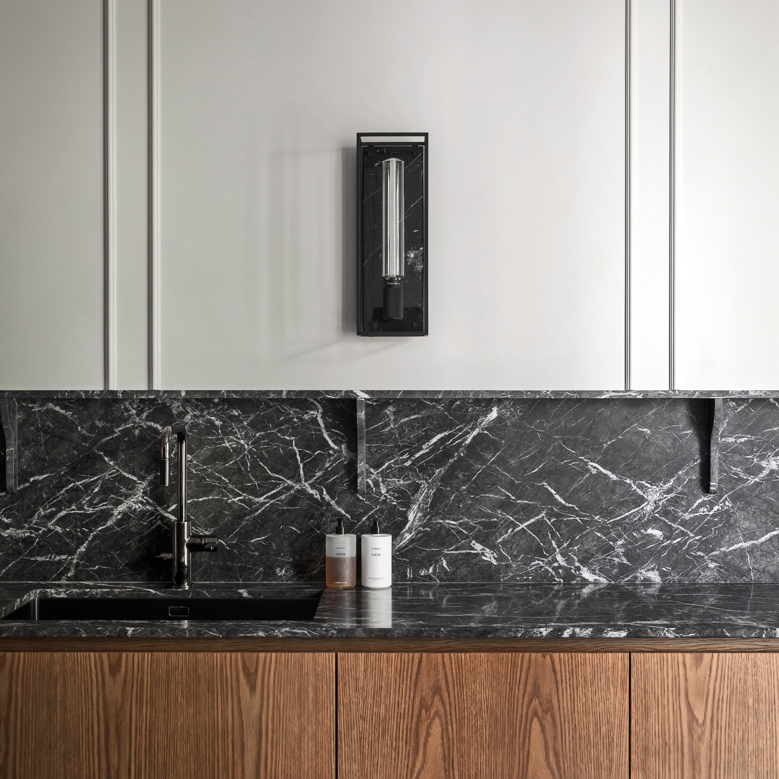 Buster and Punch caged wall lamp large i sort metal med bagplade i sort marmor.