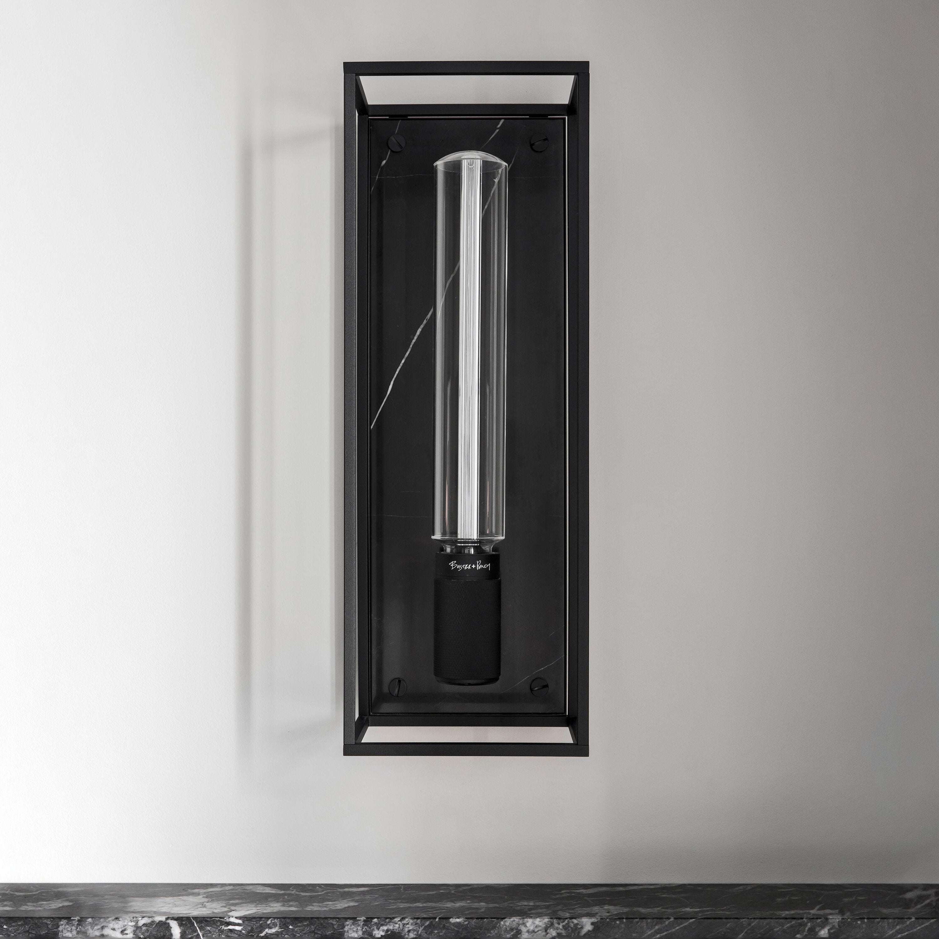 Buster and Punch caged wall lamp large i sort metal med bagplade i sort marmor.