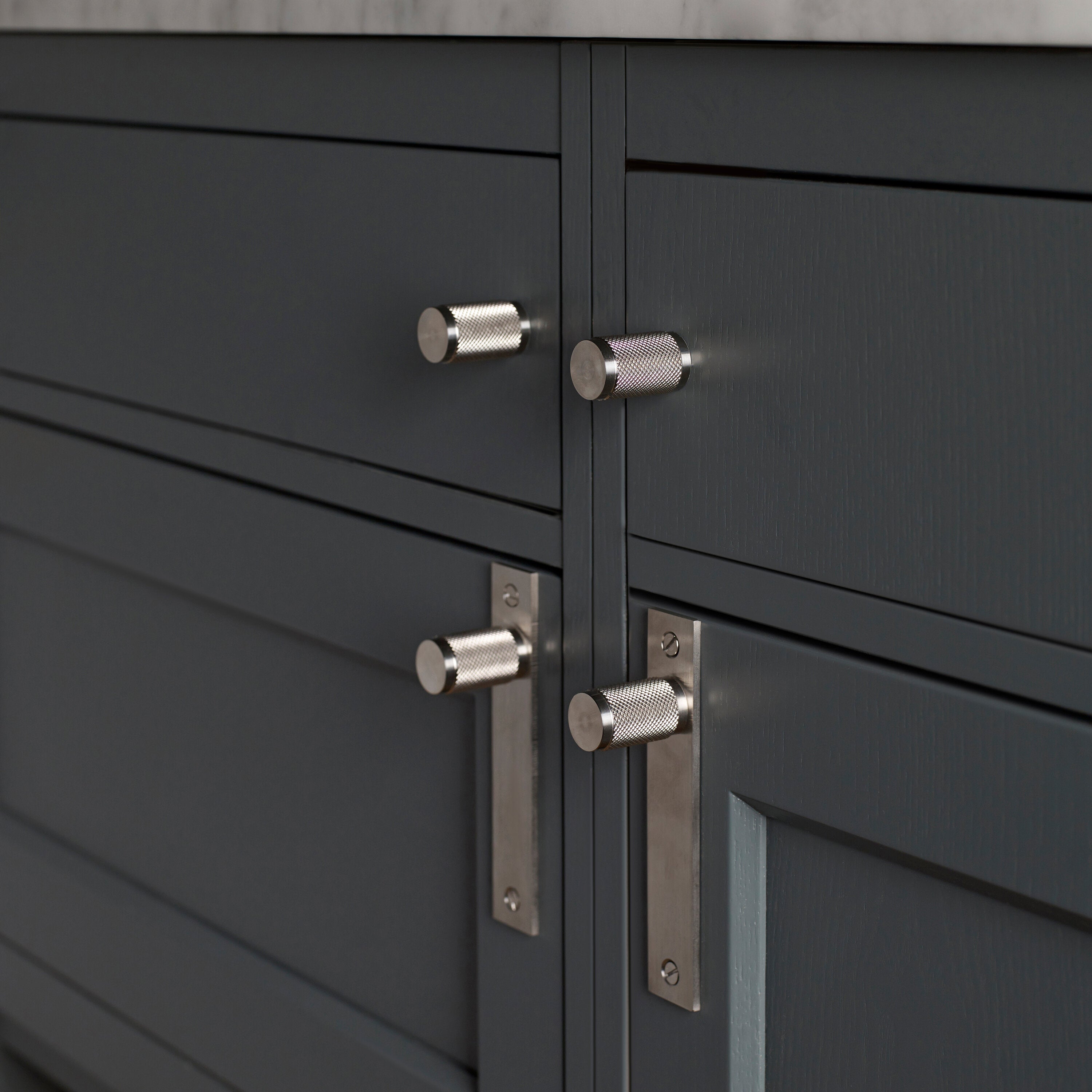 Eksklusiv møbelknop med bagplade fra Buster + Punch i rustfri stål med diamond cut (cross) mønster. Bagpladen kan bl.a. anvendes til at dække over eventuelle gamle monteringshuller.