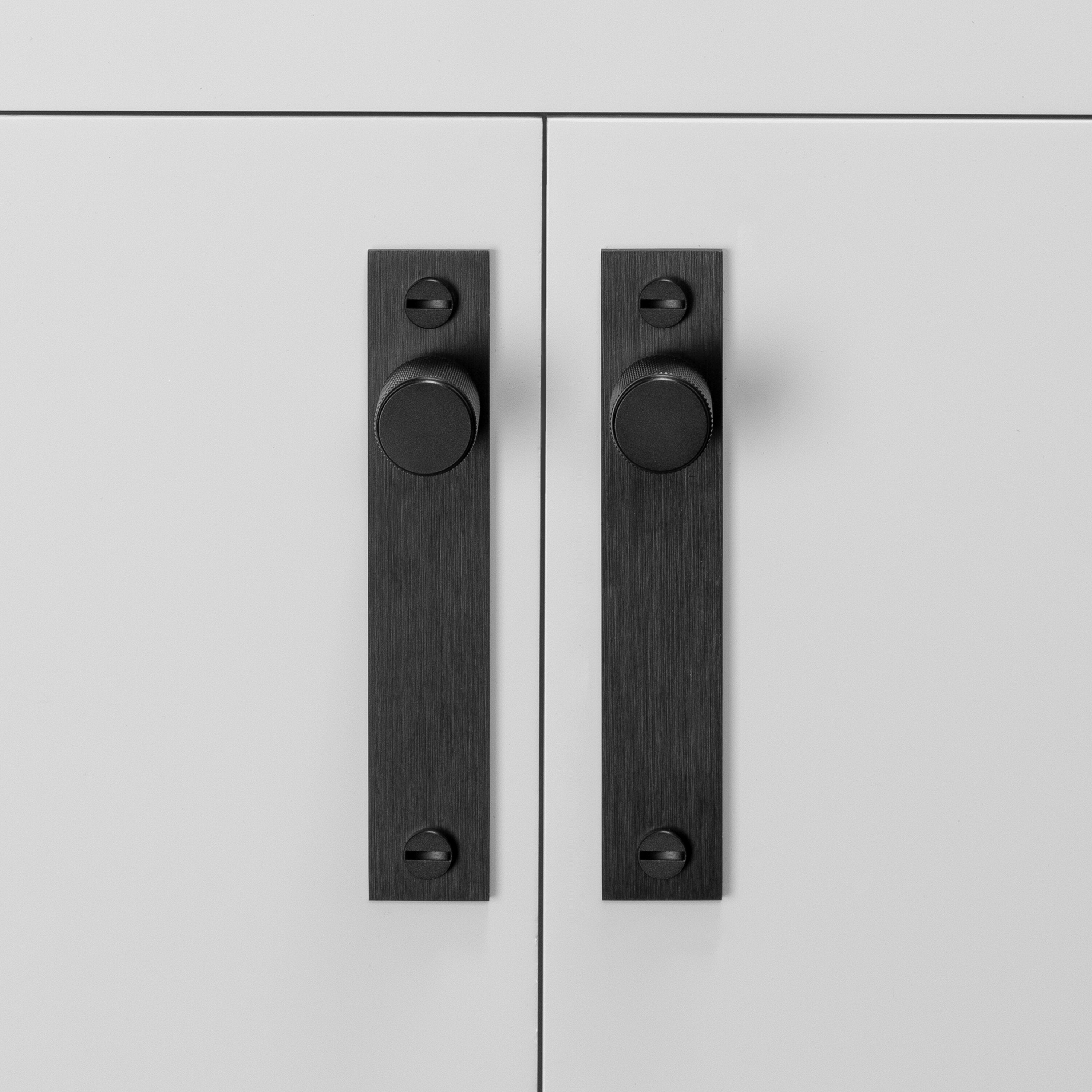 Køkkenknopper med bagplade fra Buster + Punch i sort aluminium med diamond cut (cross) mønster. Denne knop kan bl.a. bruges til at dække for eventuelle gamle monteringshuller.