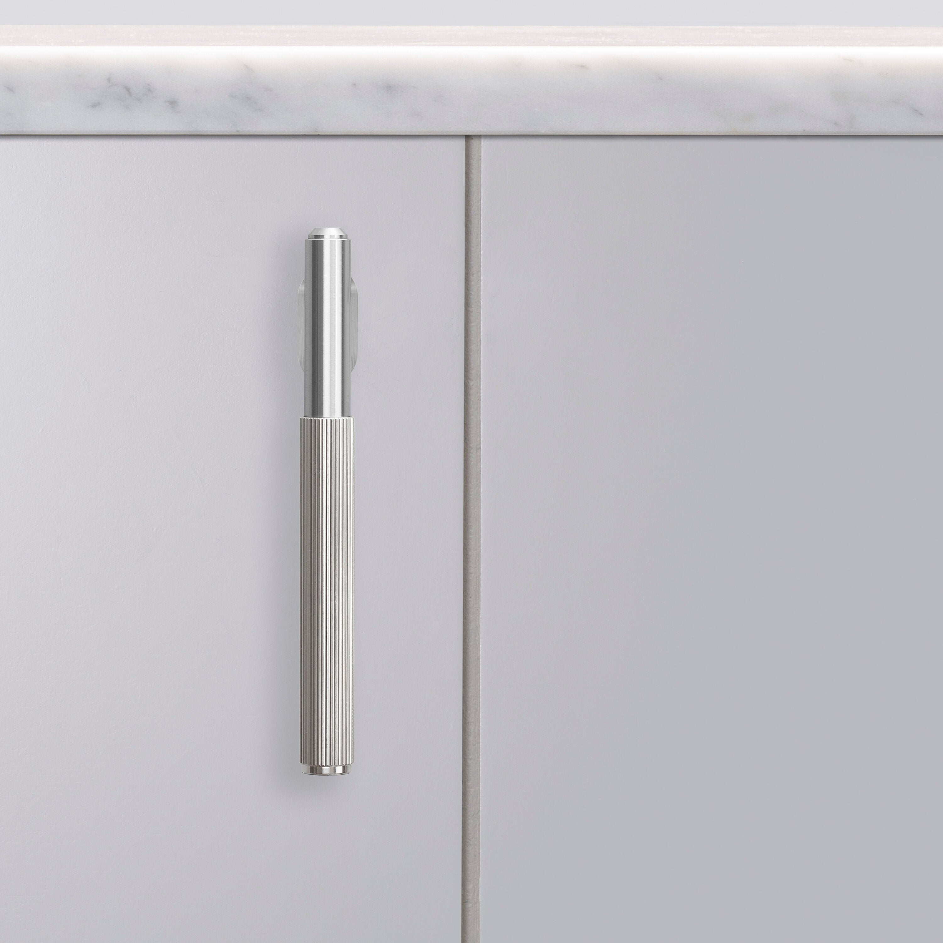 L-bar køkkengreb fra Buster + Punch i rustfri stål med linjeret mønster.