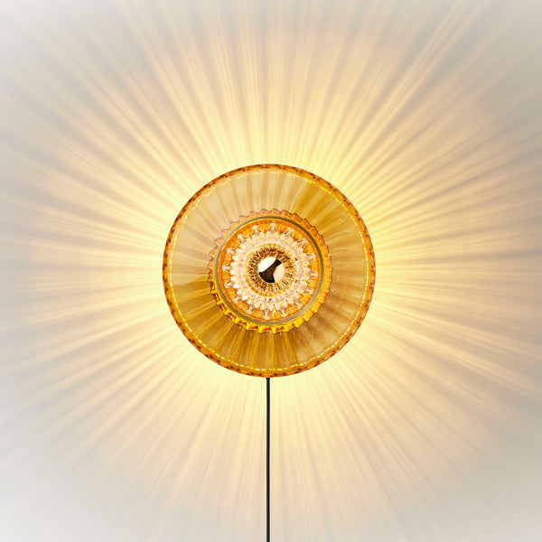 Eyeball er en mønstret/plisseret indsats i klar glas, som skaber et ekstra stærkt lysspil til New wave Lamperne fra Design by Us.