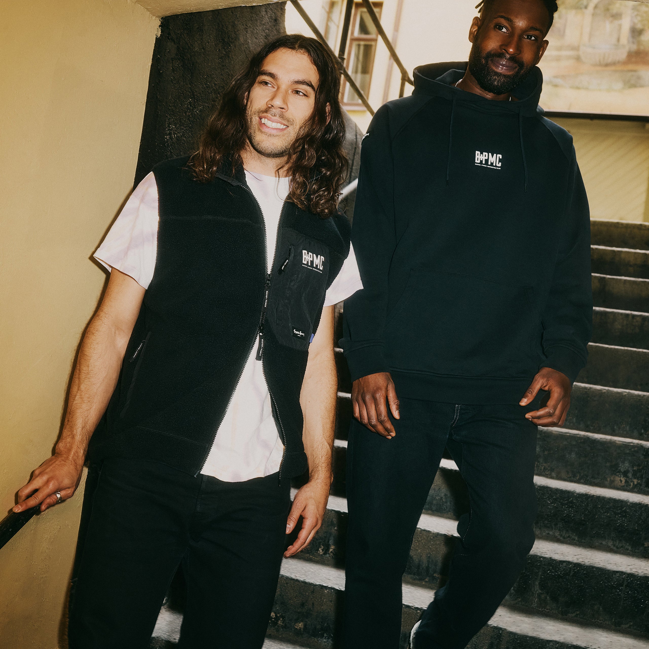 Kraftig sort hættetrøje med Buster + Punch logo på brystkasse og skulder.