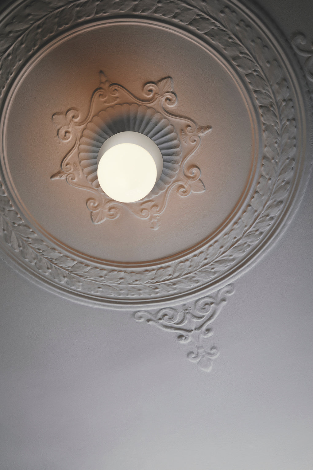 Loftlampe med lampeskærm af opalglas og sølvfarvet fatning, i stuk i roset