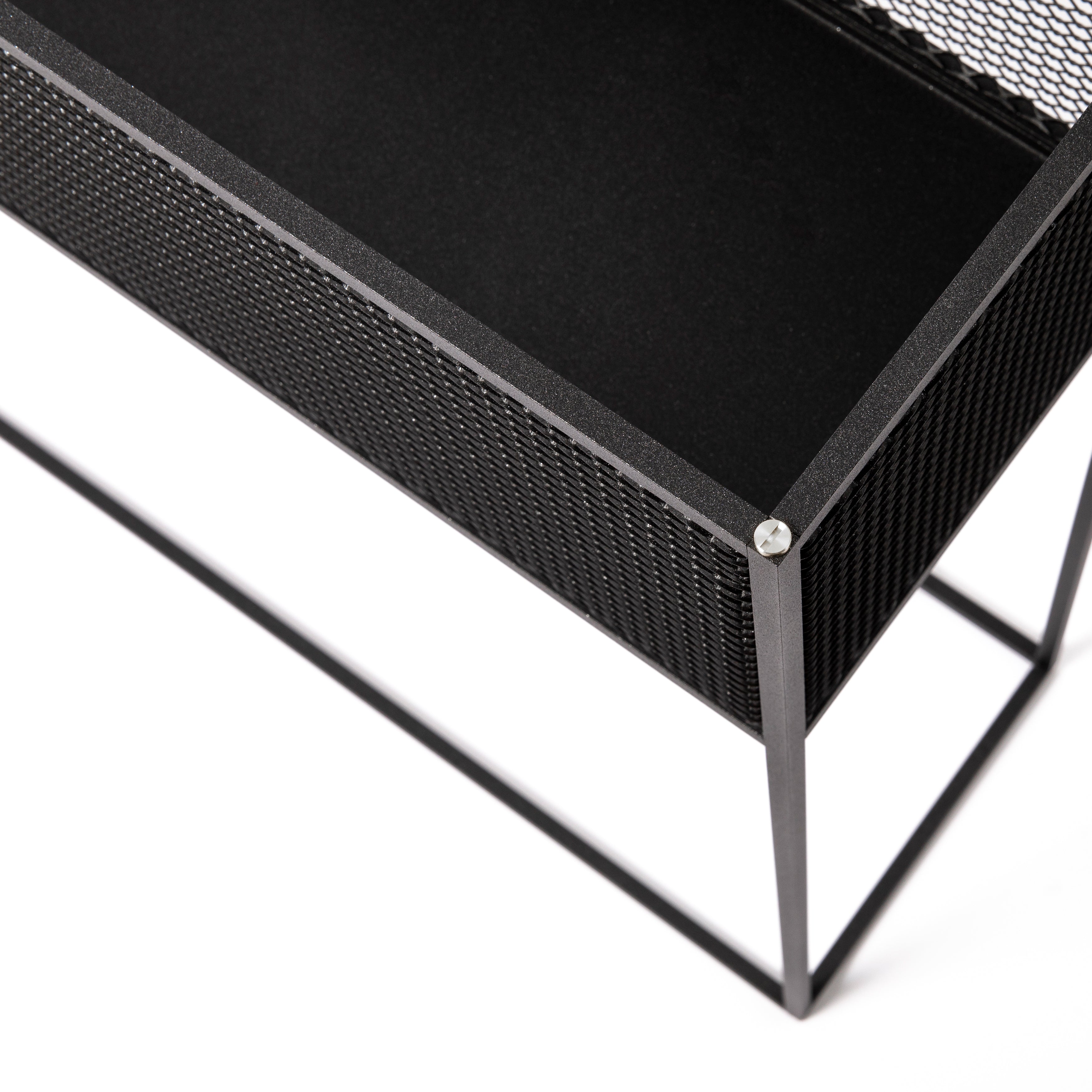 Firkantet og sort plantekasse i stålramme med meshed/hullet design på siderne. Der medfølger detaljer/skruer i både stål og messing.