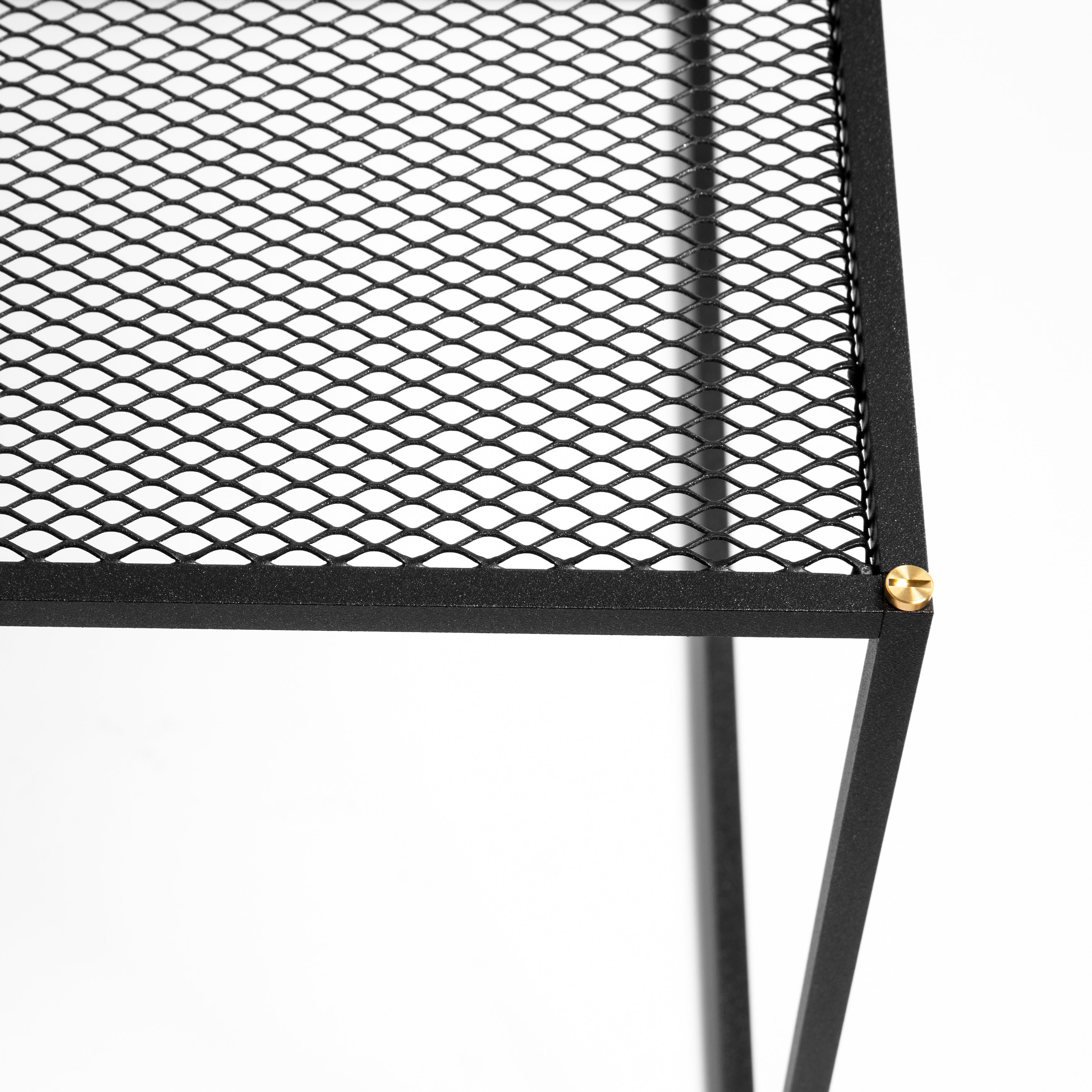 Firkantet sort sofabord med bordplade i meshed/hullet mønster. Vælg mellem detaljer/skruer i messing eller stål (medfølger).