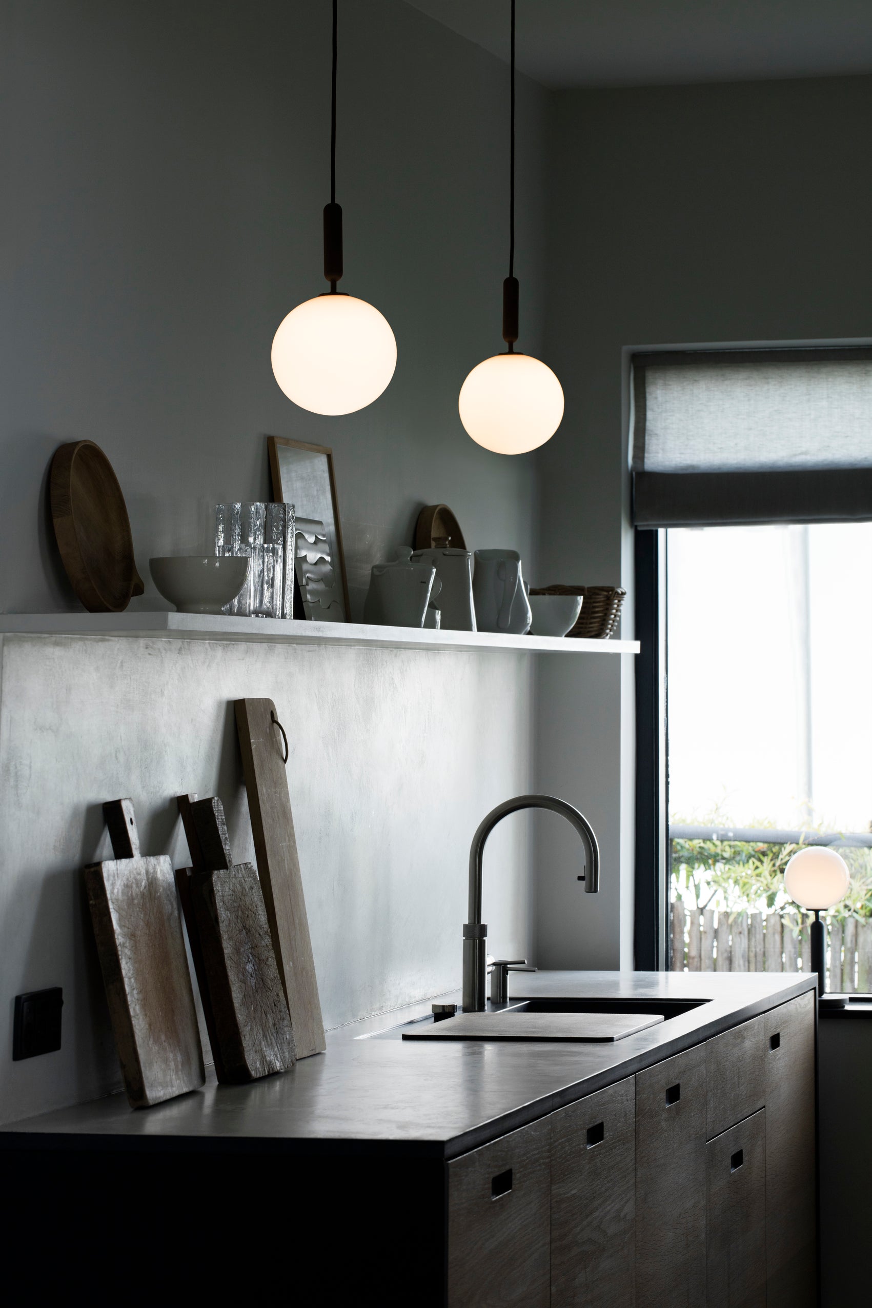 To pendler med runde skærme af opalglas og aflang grå fatning, over køkkenbord