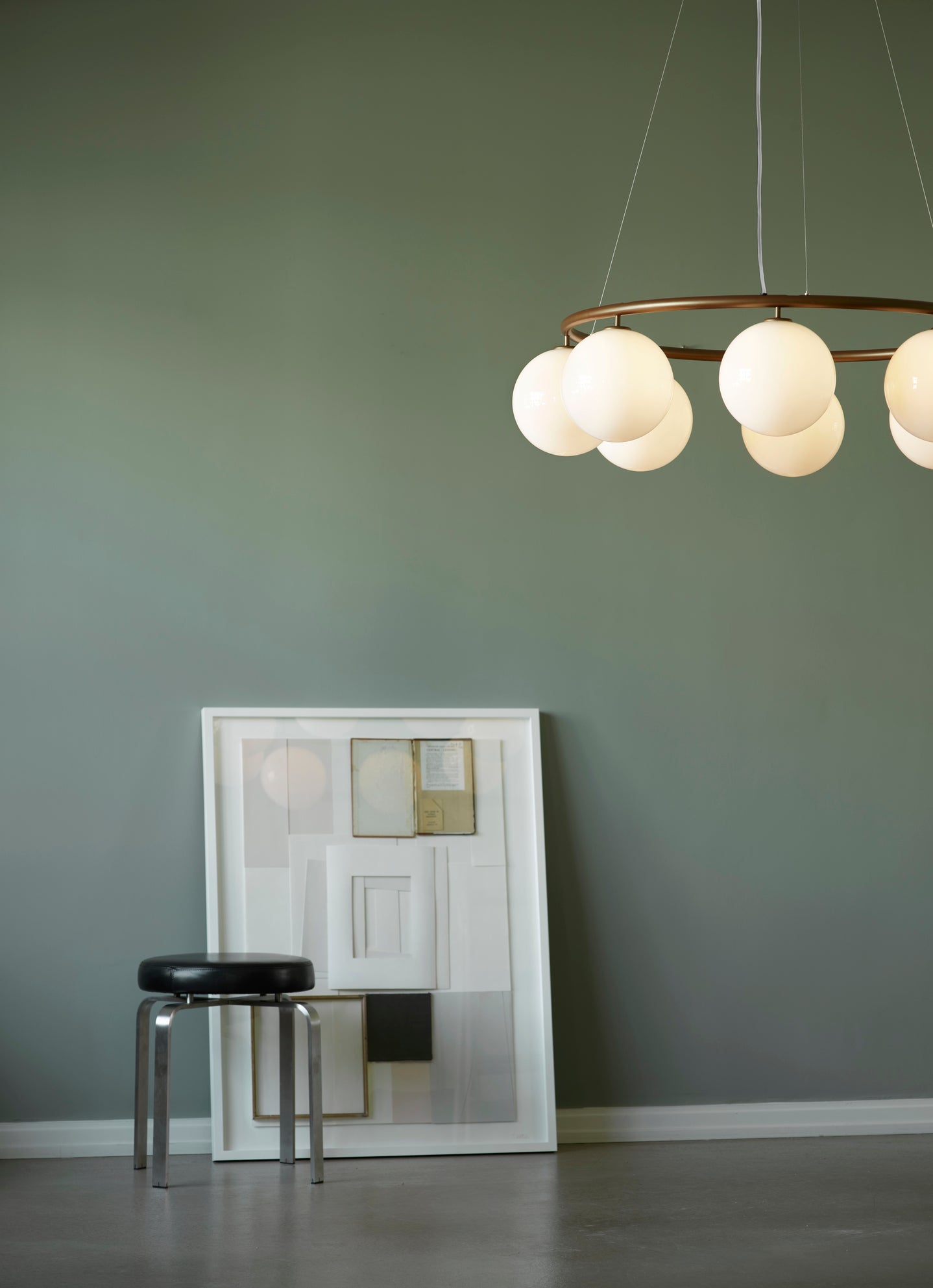 Lysekrone bestående af otte runde skærme i opalglas samt bruneret krone, hængende i dagligstuemiljø