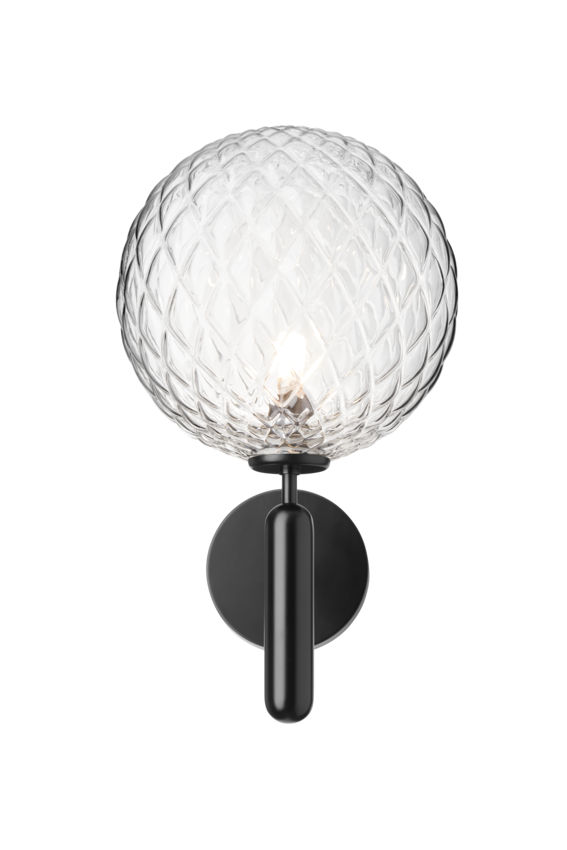 Væglampe med rund skærm af klart optikglas og sort stel, på hvid baggrund