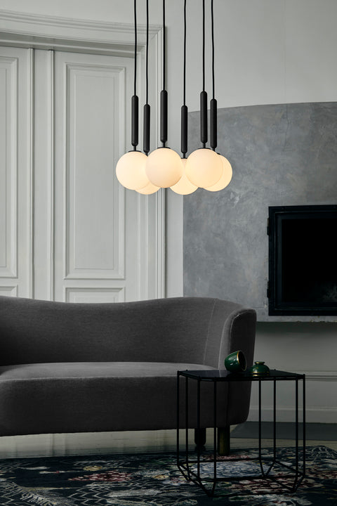 Pendel bestående af seks runde skærme af opalglas med gråt ophæng og sort ledning,