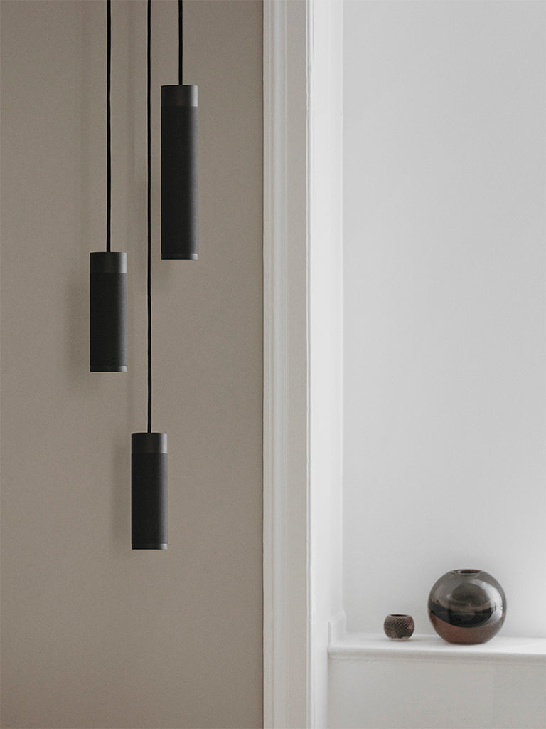 Loftlampe med tre pendler i massiv sort bruneret messing med sort stofledning