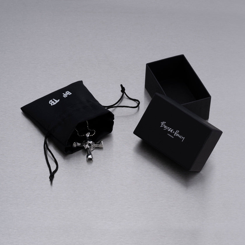 Æske indeholdende halskæde med et vedhæng i form af et dødningehoved, som samtidig er en drum key, i stål.