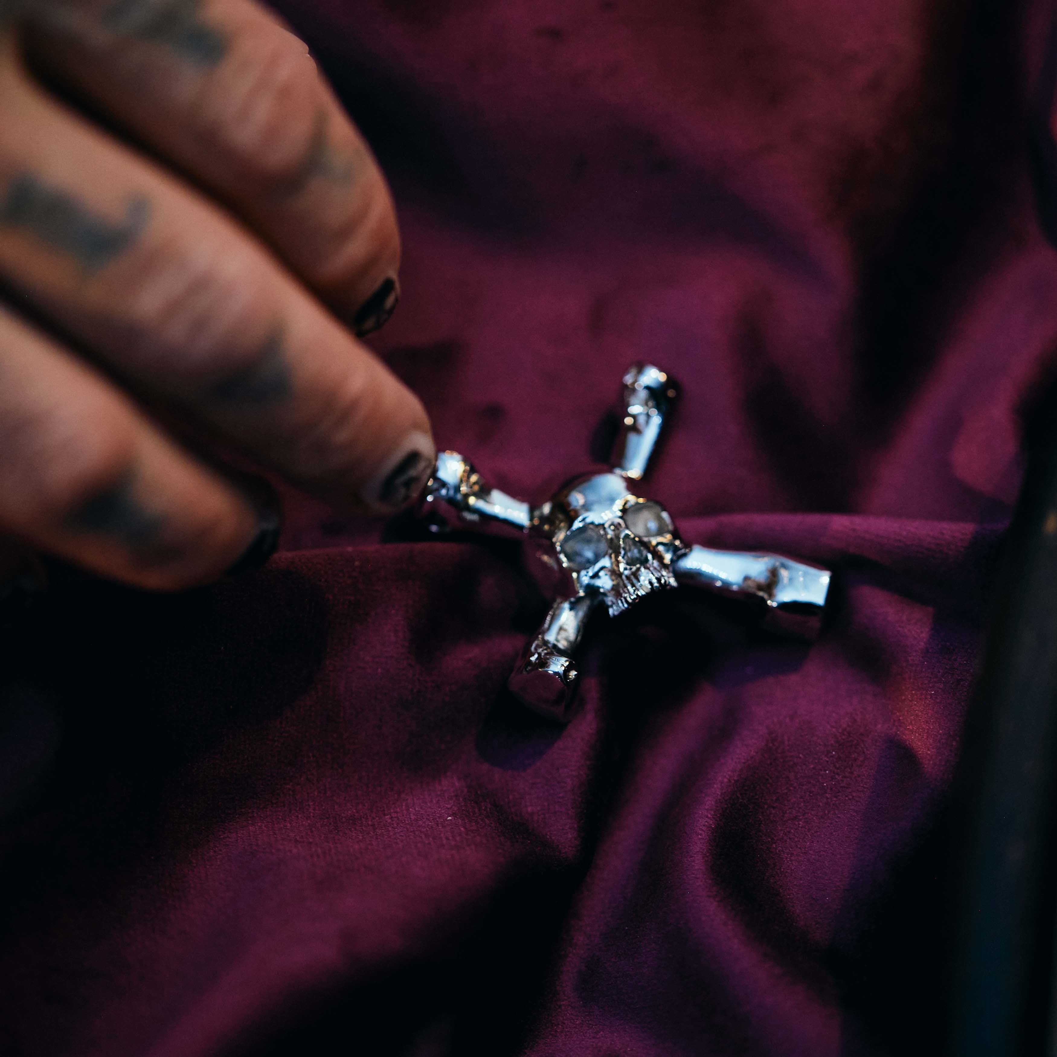 Vedhæng i form af et dødningehoved, som samtidig er en drum key, i stål.edhæng i form af et dødningehoved, som samtidig er en drum key, i stål.