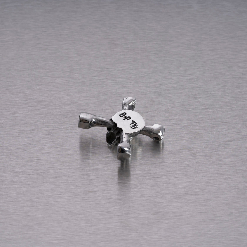 Halskæde med et vedhæng i form af et dødningehoved, som samtidig er en drum key, i stål.