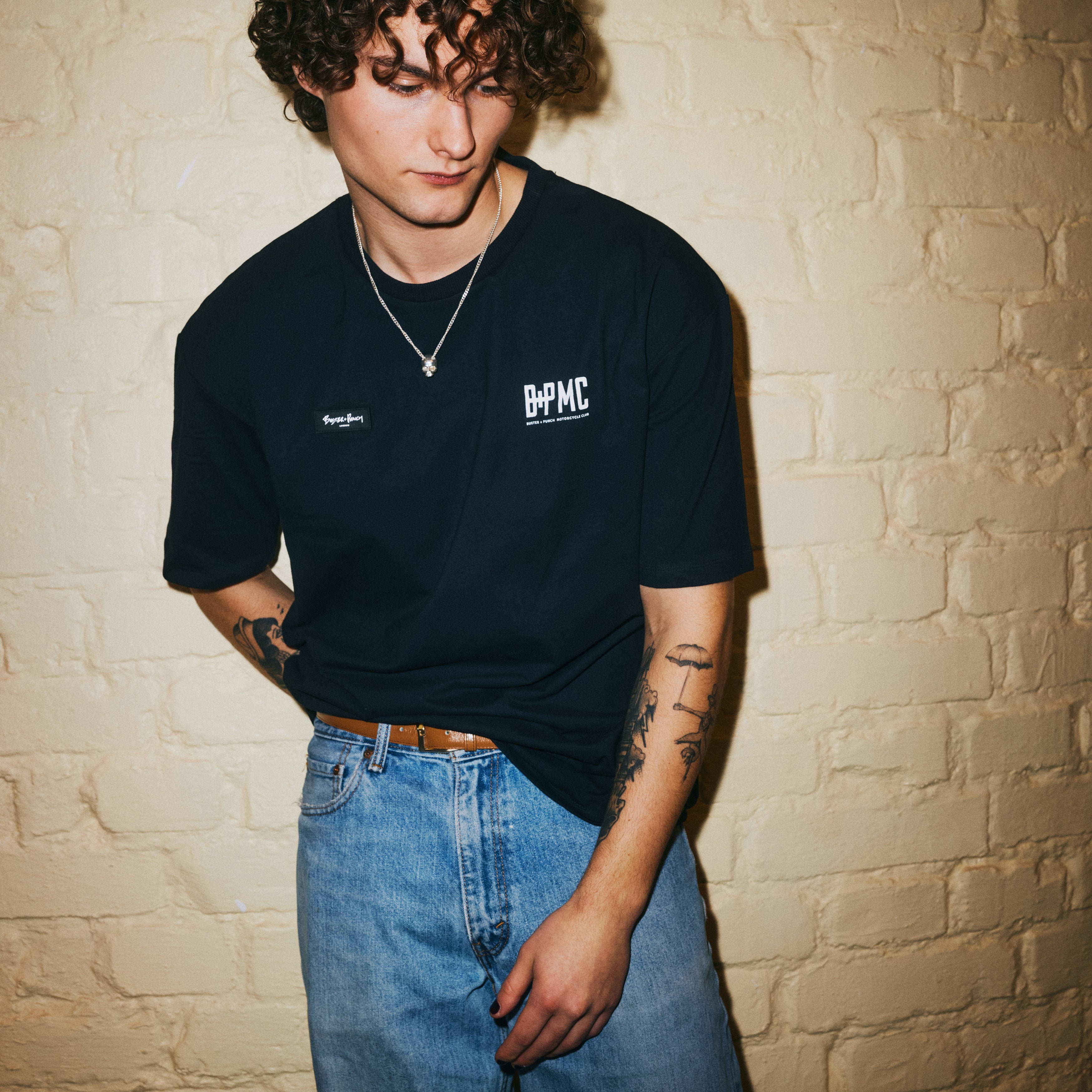 Sort T-shit i bomuld med logo fra Buster + Punch og Travis Barker på forsiden.