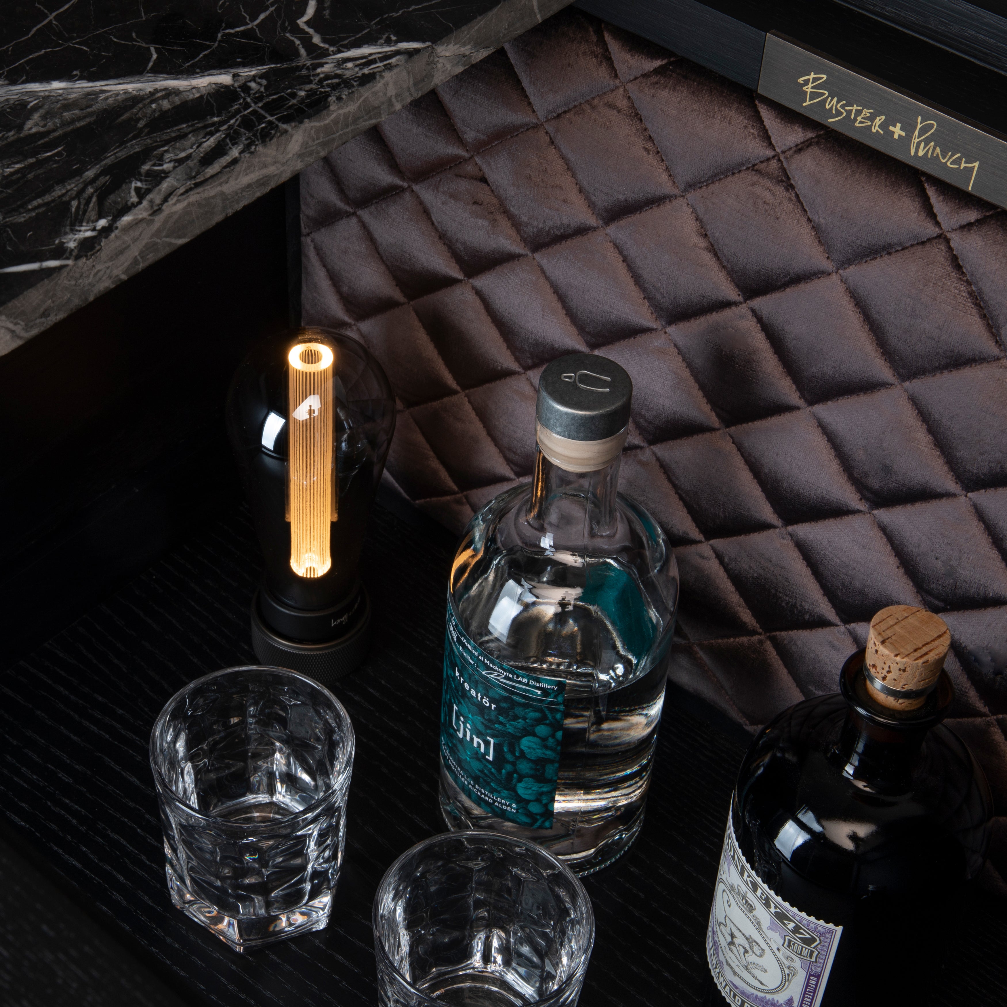 Bar i sort eg og sort marmor. Baren har en integreret lyskilde og en bordplade i sort marmor.