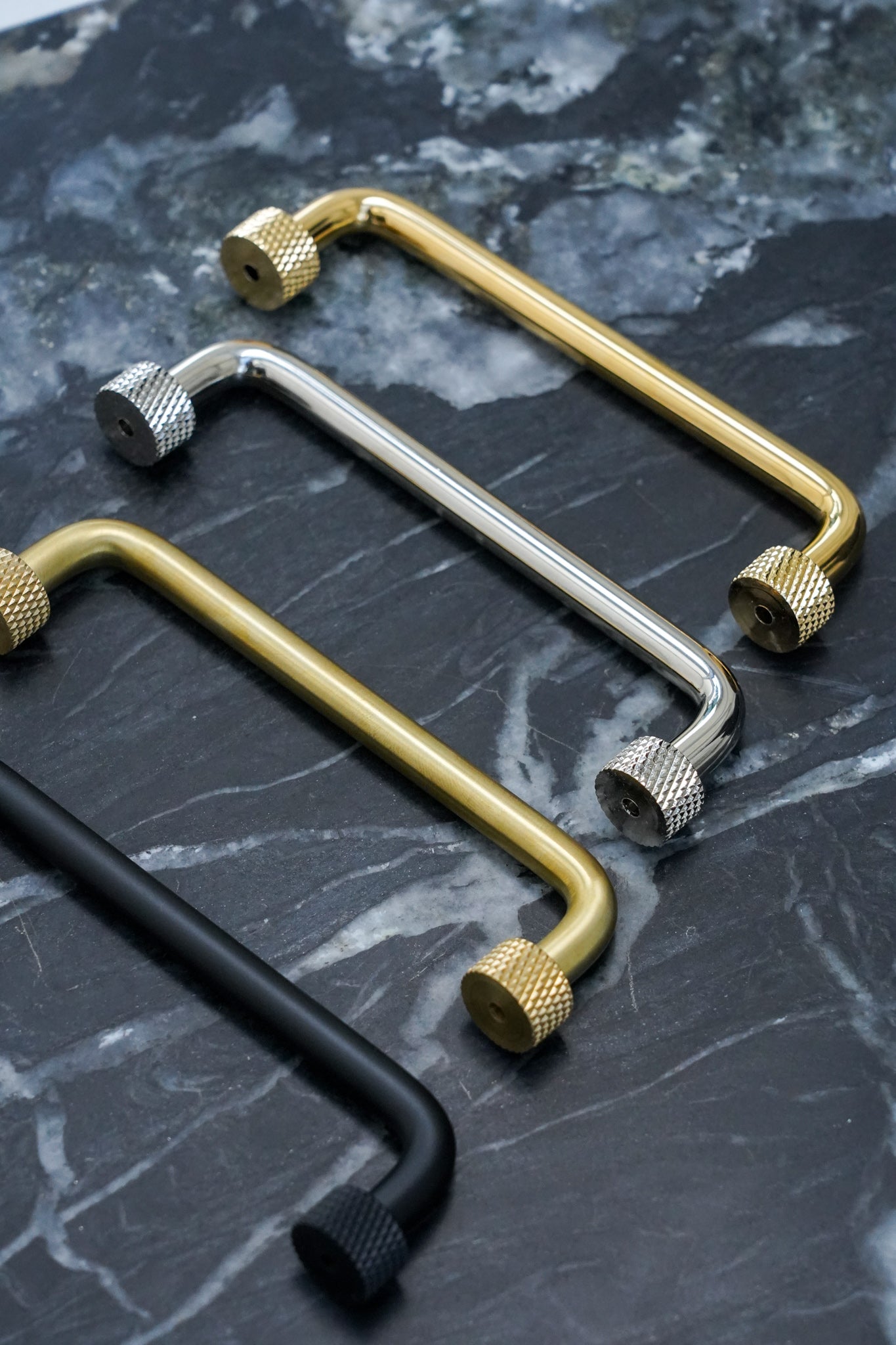 Køkkengreb i massiv blank messing uden lak. Grebet har runde fødder med riflet diamond cut mønster, som matcher til quooker armatur.