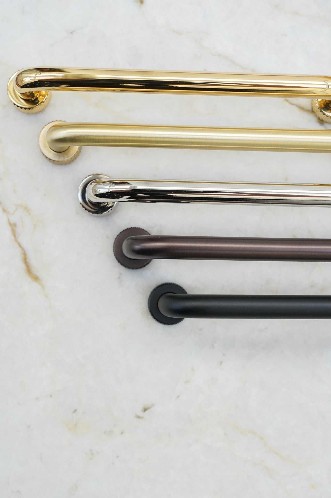 Køkkengreb i massiv messing med en mat sort overflade. Grebet har runde fødder med riflet diamond cut mønster, som matcher til quooker armatur.