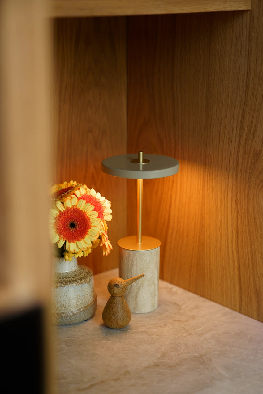 Bordlampe i en varm indretning med træ og messing