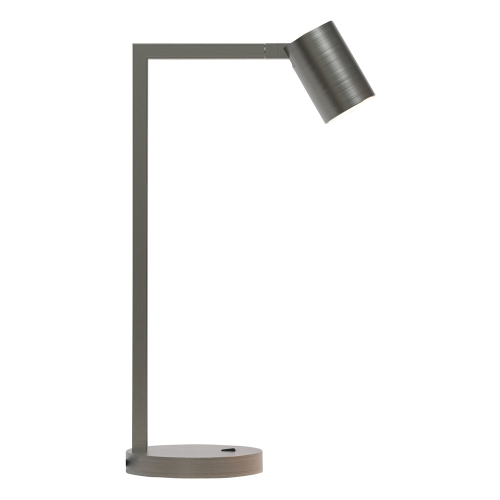 Stålfarvet bordlampe med justerbar hoved. Lampen har et enkelt design med firkantede linjer/vinkler.