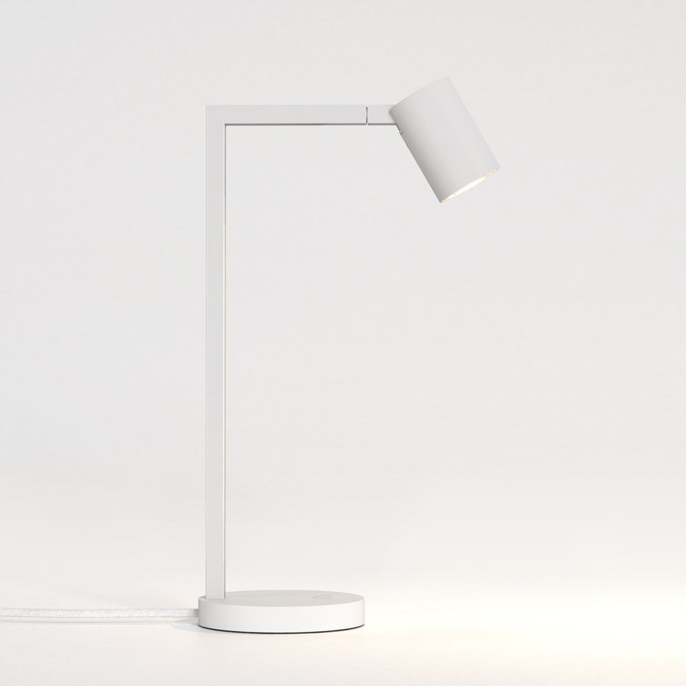 Hvid bordlampe med justerbar hoved. Lampen har et enkelt design med firkantede linjer/vinkler.