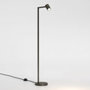 Gulvlampe i bronzefarvet stål med justerbart hoved. Lampen har et enkelt design med firkantede vinkler og en rund fod.