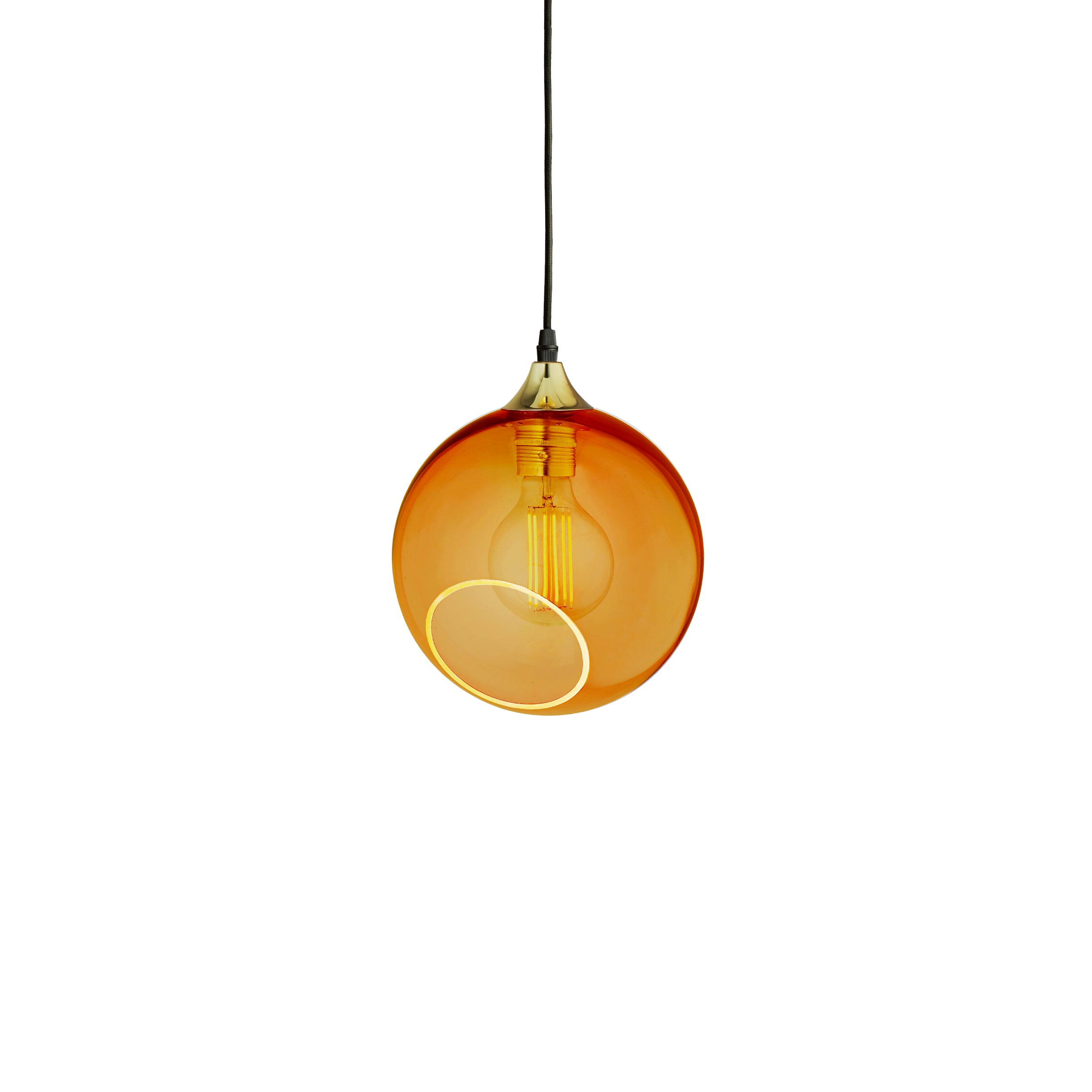 Rund lampe i orange/gul glas med et afskåret stykke med kig til pæren. Fatning of rosetten er guldfarvet og ledningen er af sort stof.