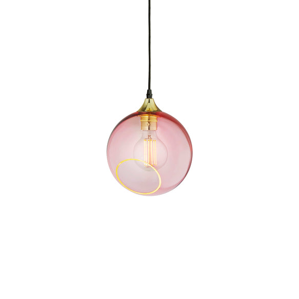 Rund lampe i rosafarvet glas med et afskåret stykke med guldkant. Fatning er guldfarvet og ledningen er af sort stof.