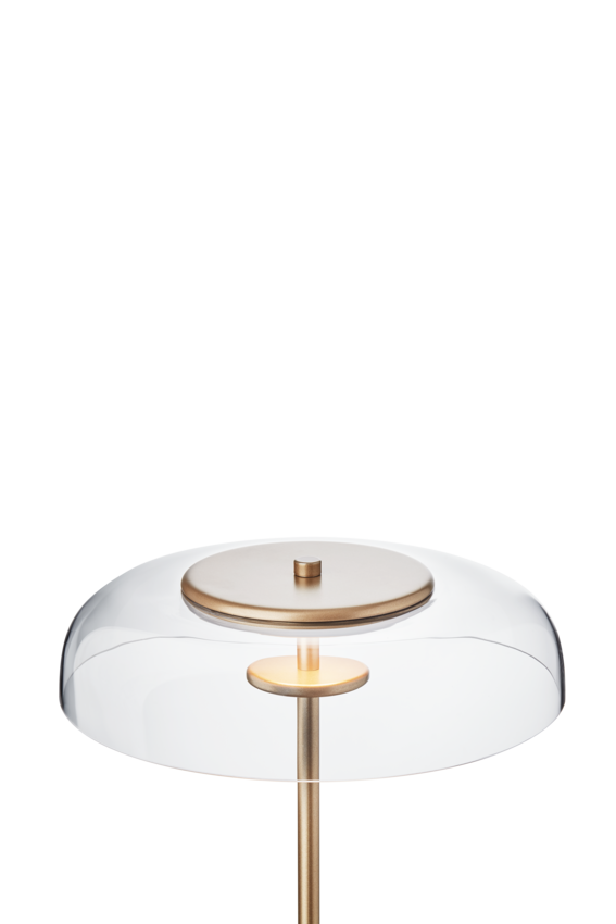 Gulvlampe med gyldent stel og fatning samt klar glasskærm, på hvid baggrund