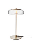 Bordlampe med gyldent stel og fatning samt glasskærm, på hvid baggrund