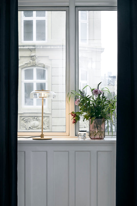 Bordlampe med gyldent stel og fatning samt glasskærm, i vindueskarm