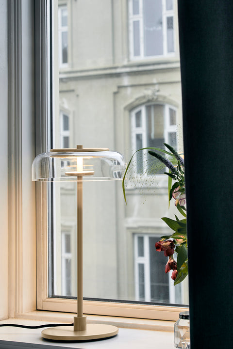 Bordlampe med gyldent stel og fatning samt glasskærm, i vindueskarm