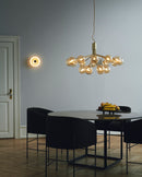Rund væglampe af opalglas med gylden fatning, i dagligstuemiljø
