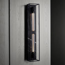 Buster and Punch caged wall lamp X-large i sort metal med bagpanel i sort marmor.