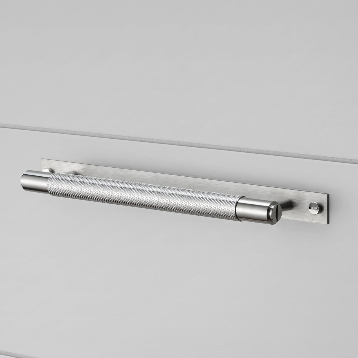 Køkkengreb til køkkenlåger fra Buster + Punch i rustfri stål med bagplade og diamond cut mønster.