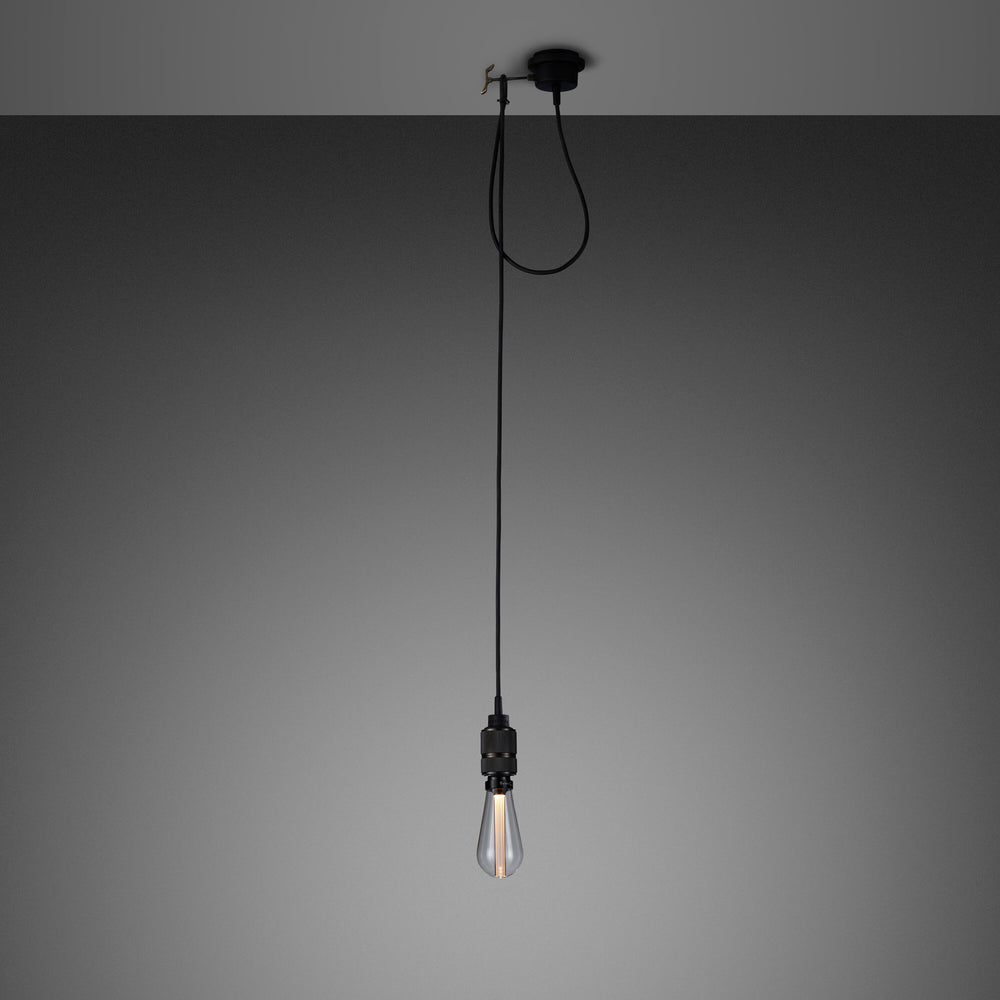 Enkel pendel lampe med fatning i bruneret massiv messing med diamond cut (cross) mønster fra Buster + Punch. Lampen har en krog i bruneret massiv messing, som gør det muligt at justere højden på lampen.