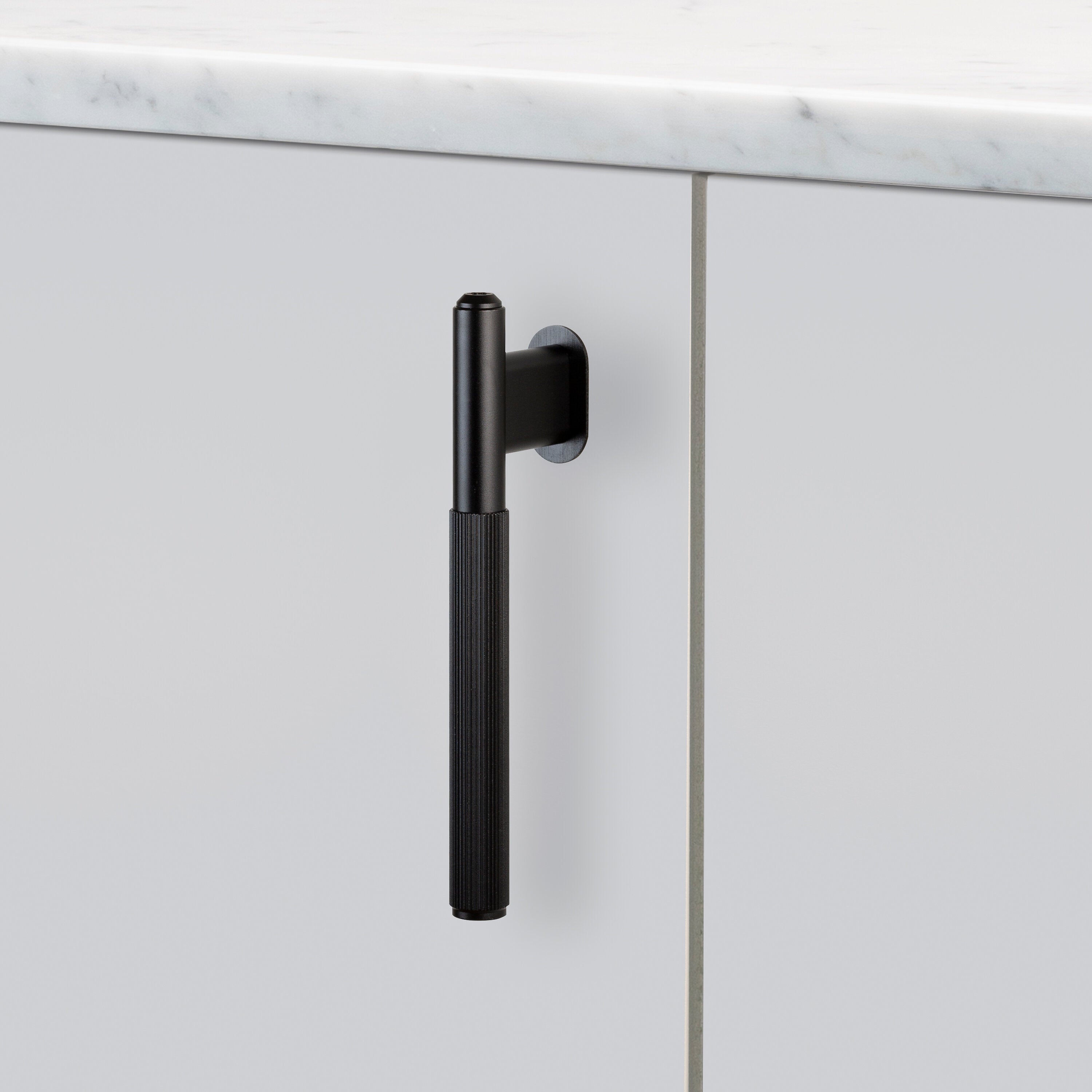 L-bar køkkengreb fra Buster + Punch i sort aluminium med linjeret mønster.