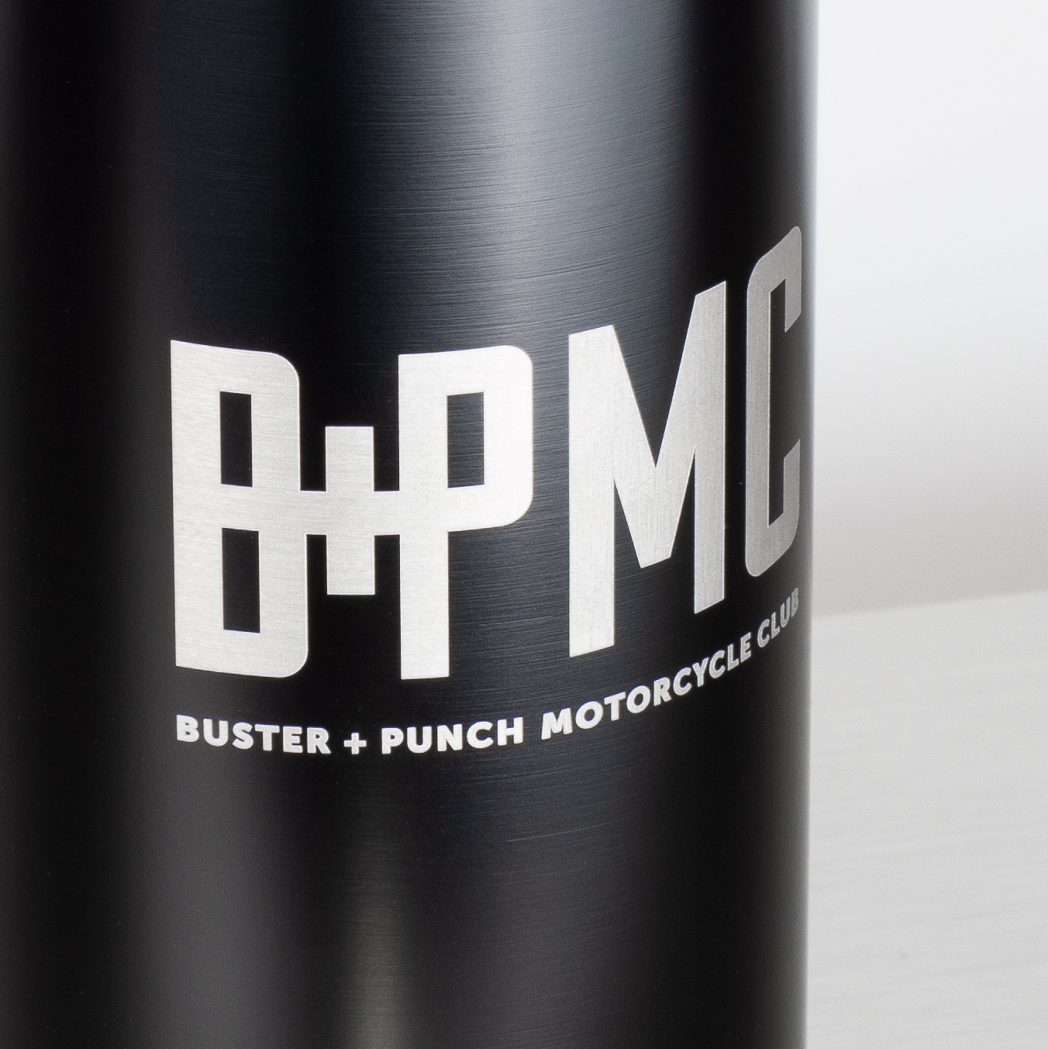 Drikkedunk i sort og rustfri stål med hank, skruelåg og med Buster + Punch logo.