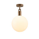 Loftlampe med rund skærm i opalglas og fatning i messing, på hvid baggrund