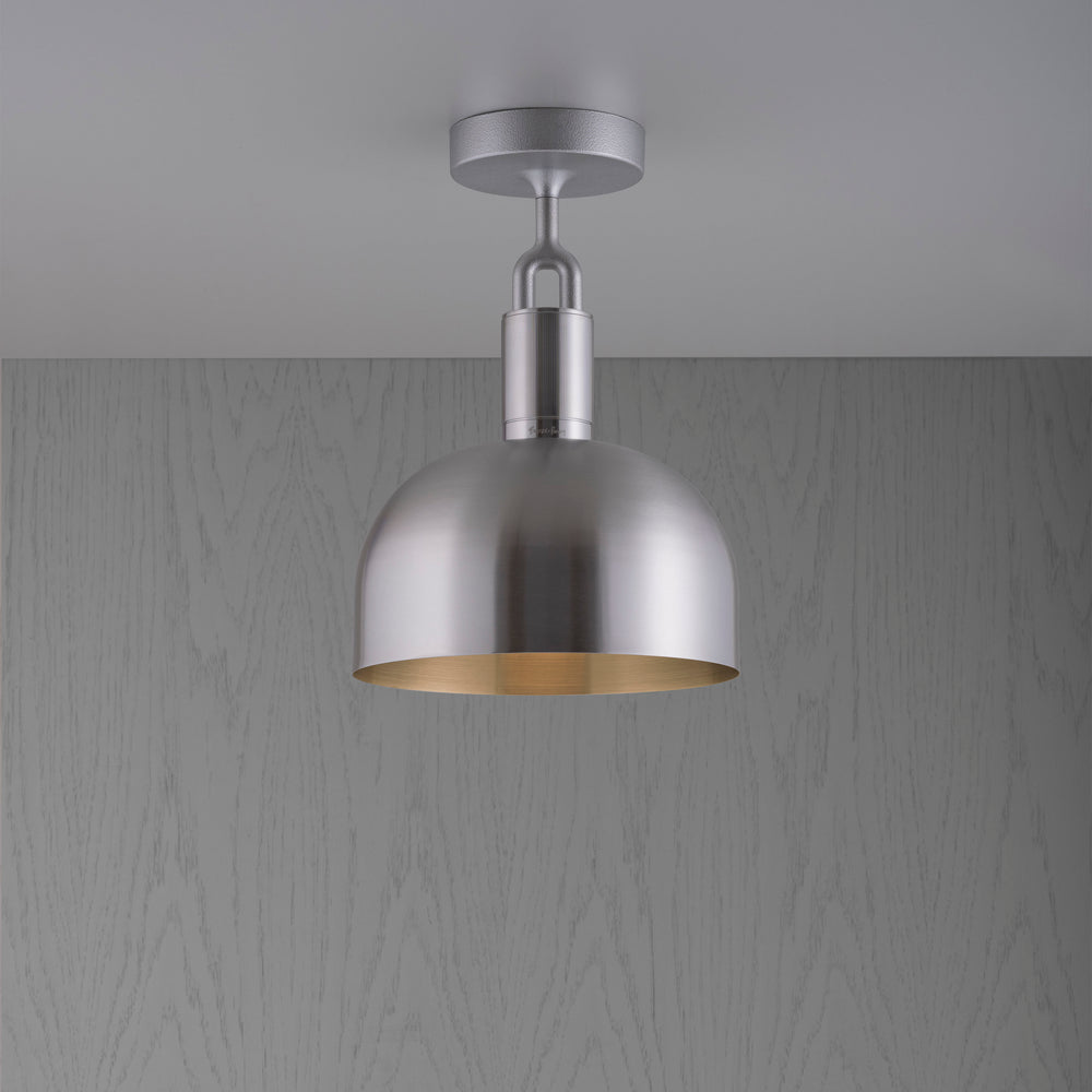 Loftlampe med skærm og fatning af stål, på grå baggrund.
