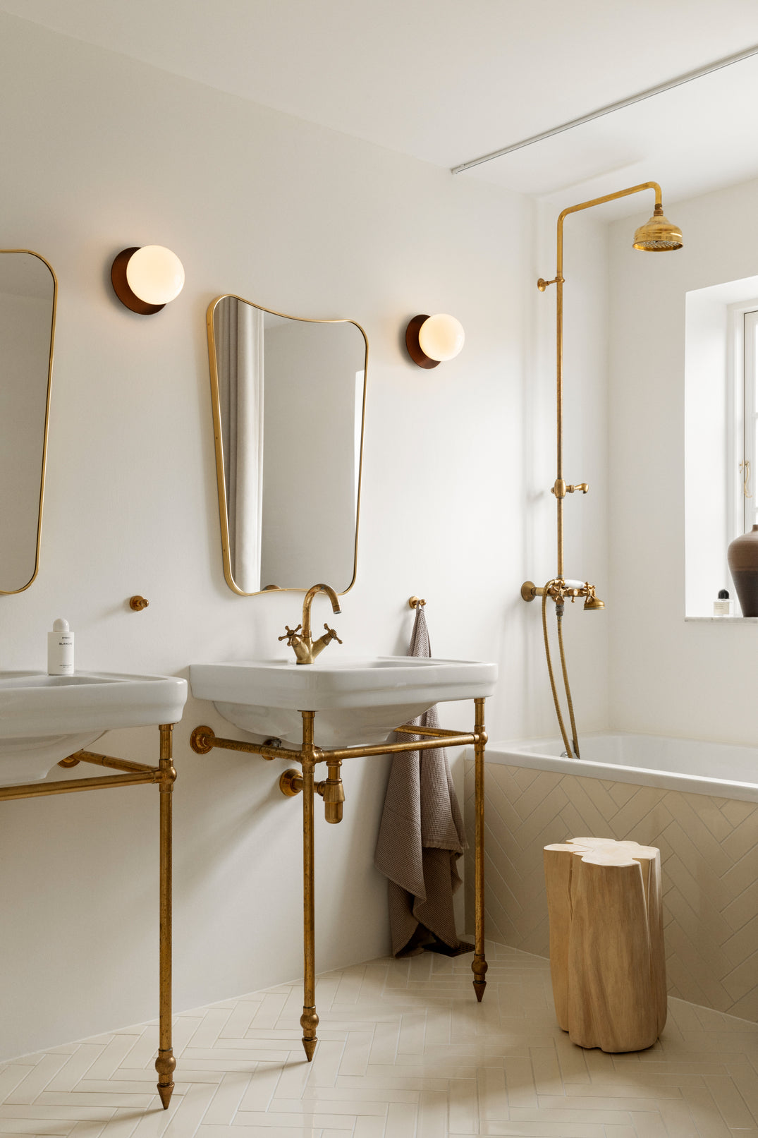 To væglamper med lampeskærme af opalglas og gylden fatning, ved spejle på badeværelse