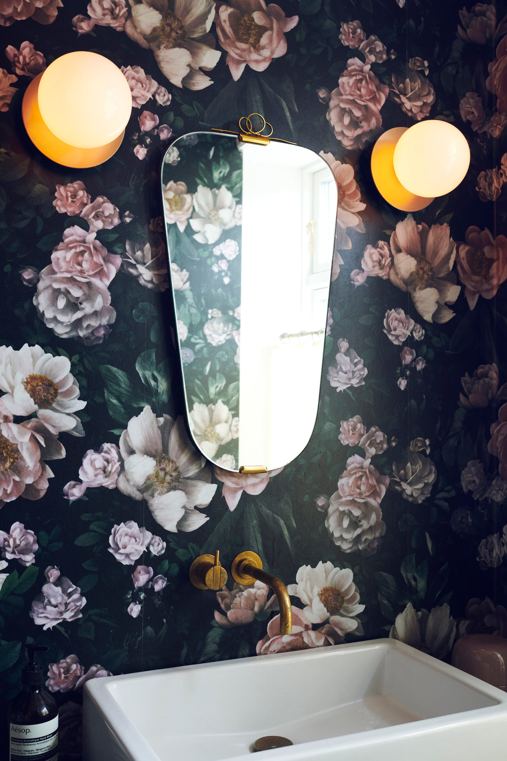 Væglamper med lampeskærme af opalglas og gylden fatning, på badeværelse